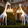Life-Size Giraffe Statue Holding a Chandelier In Its Mouth
